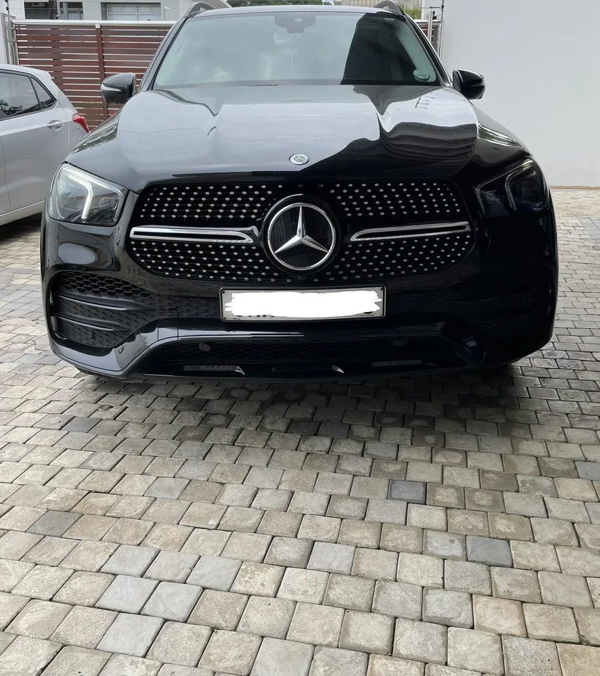 Glossy black Mercedes-Benz SUV parked on a home driveway after detailing
